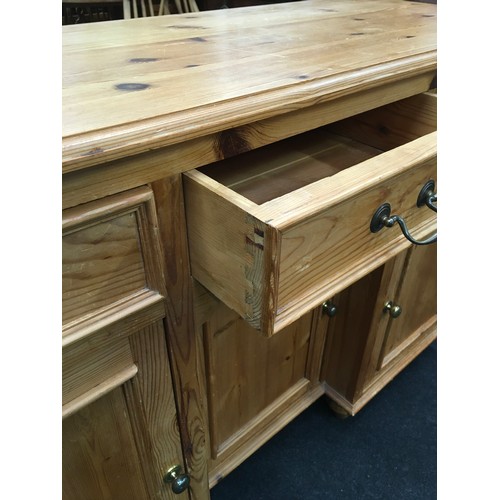 242 - Pine 3 draw over 3 door side board with brass handles and turned feet 85x125x45cm