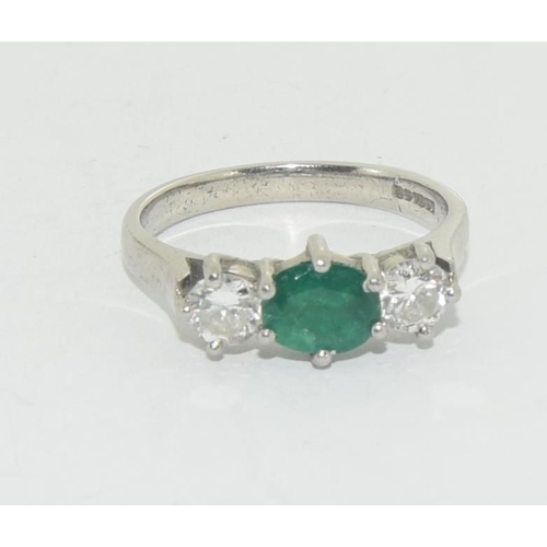 604 - Emerald approx. 50 points centre and two approx. 20 points each diamonds set in platinum ring Size O... 