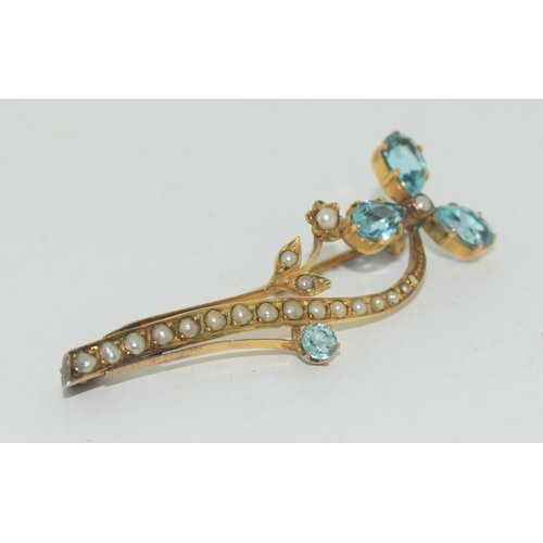 585 - An antique gold and seed pearl blue stoned floral brooch.