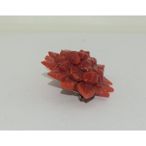 426 - An antique hand carved natural coral floral brooch.