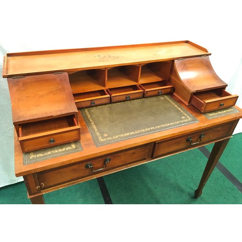 12 - A ladies writing table with leather inserts, brass drop handles on tapered supports. 96x106x56 cms.