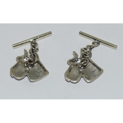 425 - A Pair of silver dog head cuff links set with Ruby eyes.