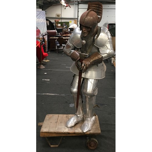 34 - A large life size figure of a knight in shining armour carrying a sword 160cm tall together with a v... 