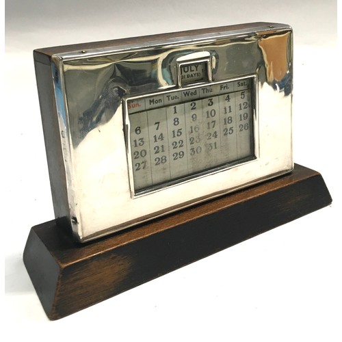49 - Silver frame on wooden base desk calendar