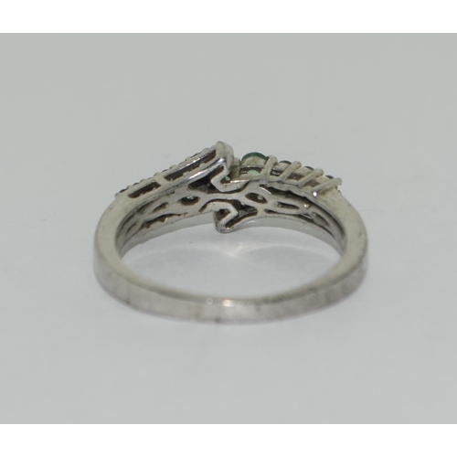 406 - 925 silver twist ring, possible emeralds. Size Q.