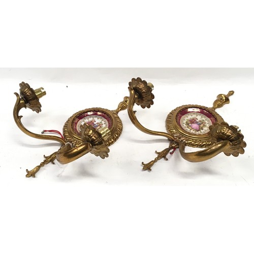 143 - A pair of decorative brass wall sconces with Meissen Limoges pictoral plaques together with a three ... 