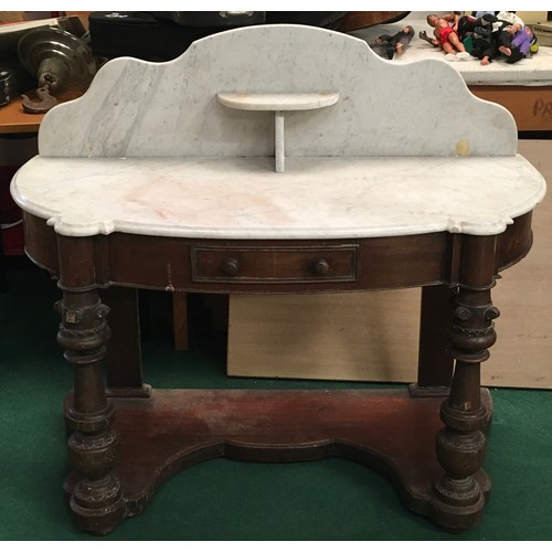 521 - A Victorian mahogany marble topped washstand with splash back on turned supports and drawer to centr... 