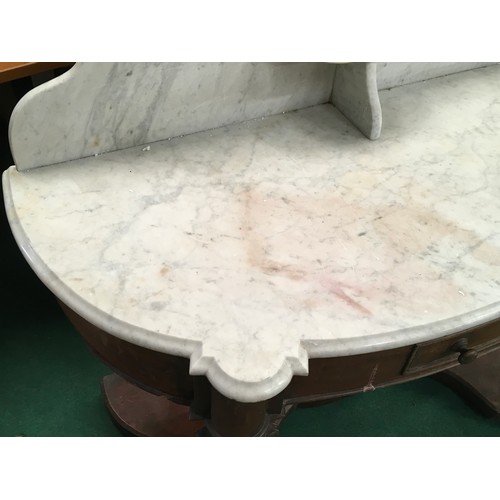 521 - A Victorian mahogany marble topped washstand with splash back on turned supports and drawer to centr... 