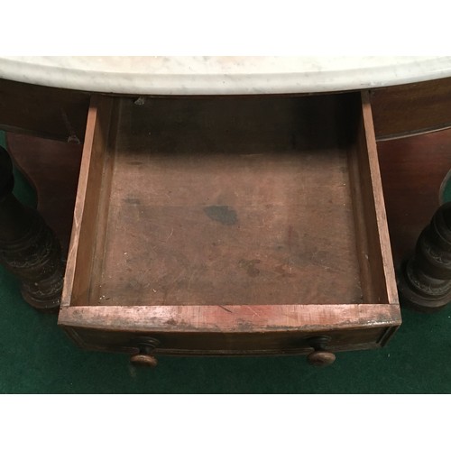 521 - A Victorian mahogany marble topped washstand with splash back on turned supports and drawer to centr... 