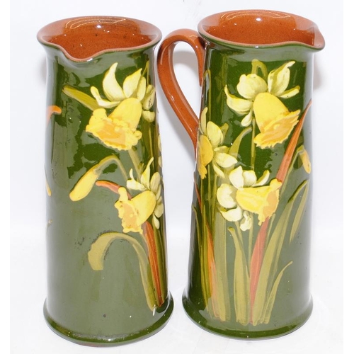 183 - Pair of large antique pottery water jugs in a Torquay ware style with daffodil decoration. 26cms tal... 