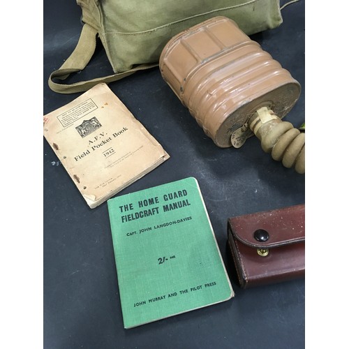 135 - Military interest: Vintage World War 2 era gas mask together with two military books and a miniature... 