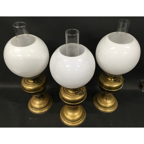 140 - Three vintage Duplex oil lamps each with glass chimney and opaline glass globe shade.