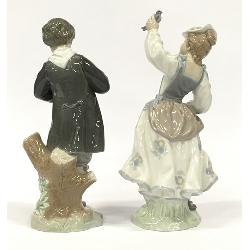 2 - Two Lladro figurines of a boy with flowers and a girl with a bird.