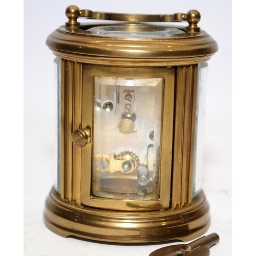 370 - Quality Matthew Norman miniature oval carriage clock with key. Seen working. All bevelled glass pane... 