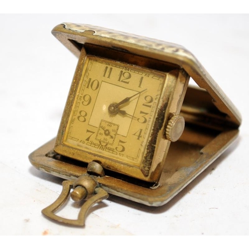 310 - Miniature 1930's manual wind folding travel clock, 4cms across not including winder. Winds and ticks... 