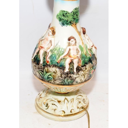 324 - A vintage Capo di Monte ceramic lamp base with applied cherubs and foliage a/f. O/all height 52cms.