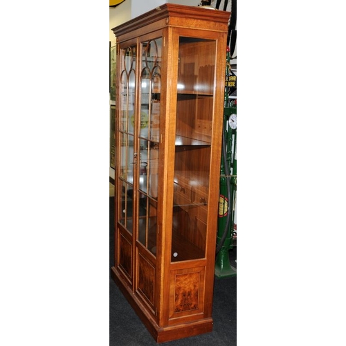 4 - Tall walnut veneer glazed two door display unit with interior lighting. Glazed panels to front and b... 