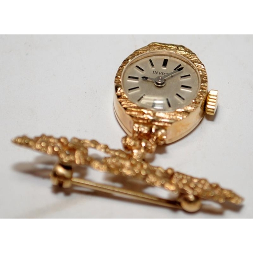 442 - 9ct gold brooch watch by Invicta. Watch winds and runs