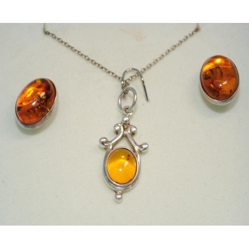 381 - Boxed Baltic amber pendant and earrings.