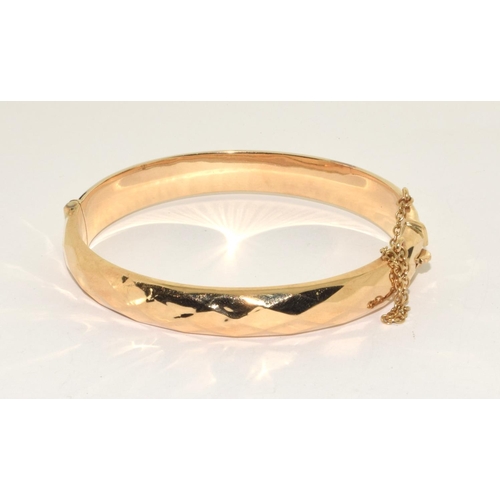 394 - 9ct gold ladies hinged bangle with safety chain 13g