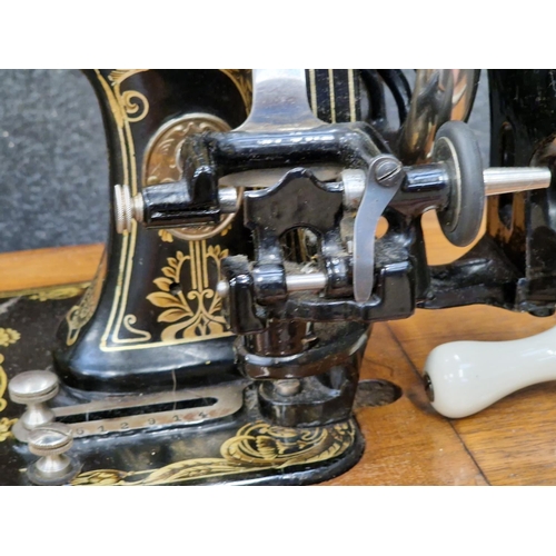 252 - Antique sewing machine in wooden case.