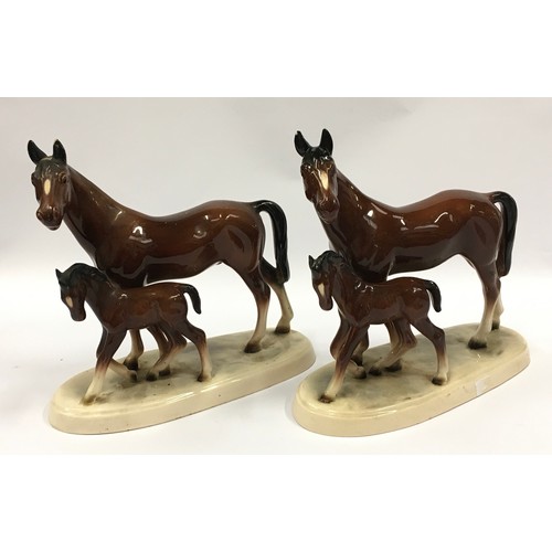 73 - A pair of ceramic horse and foal figurines with marks to bases each measuring 19cm tall.