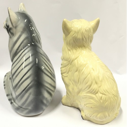 84 - A pair of ceramic sitting cat figurines the largest measuring 34cm.