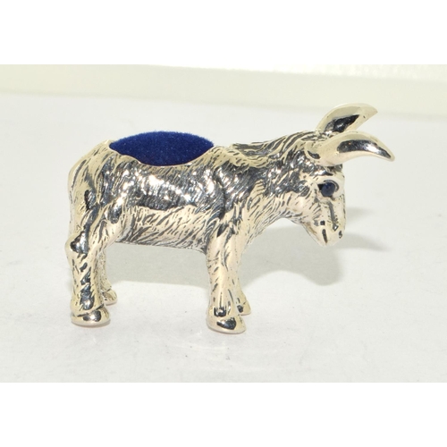 507 - A silver pin cushion in the form of a donkey with sapphire eyes.