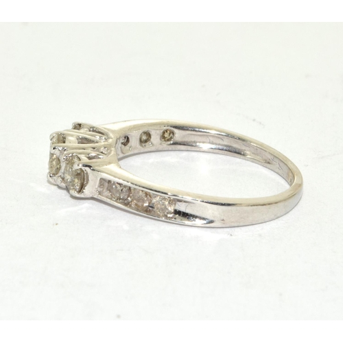 518 - A white gold three stone diamond ring of 90 points flanked by baguette shoulders Size N