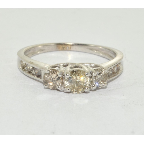 518 - A white gold three stone diamond ring of 90 points flanked by baguette shoulders Size N