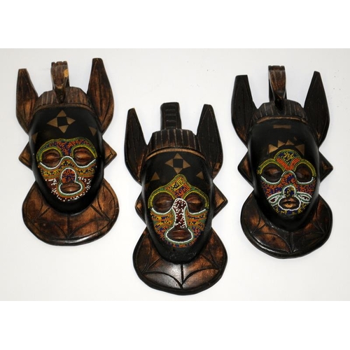 111 - Three small hand carved wooden African tribal masks. Largest is 24cms tall