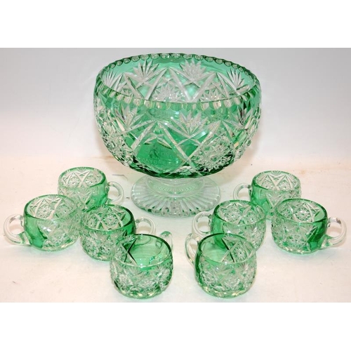 46 - Large footed emerald green cut to clear punch bowl with 8 matching glasses. Has an etched inscriptio... 