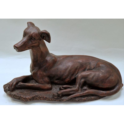 73 - A bronzed resin large figurine of a lying greyhound 52x29x21cm.