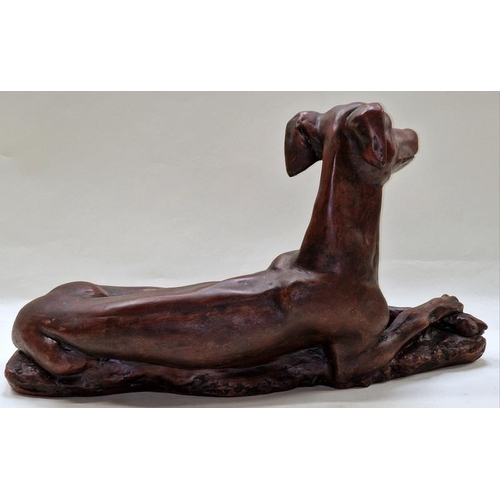 73 - A bronzed resin large figurine of a lying greyhound 52x29x21cm.