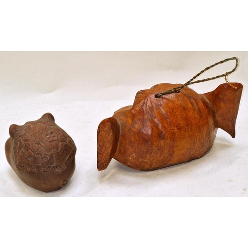 248 - An oriental pottery pigs head together with a carved wood head rattle (2).