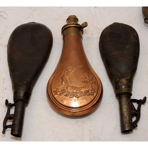 155 - A collection of antique powder flasks. Copper/brass and leather examples. 7 in lot