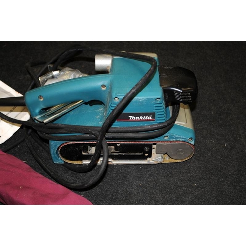 223 - A Makita electric belt sander and manual