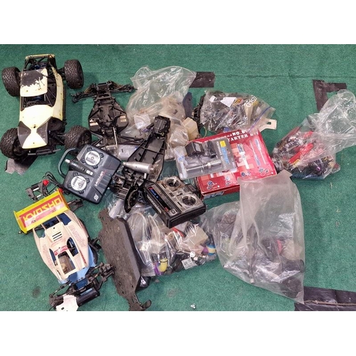 233 - Large collection of Remote Controlled car spare parts to include shells, engines, controllers etc.