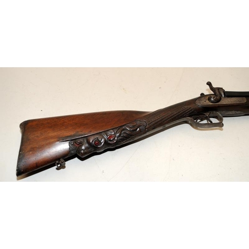 142 - Antique double barrel two trigger shotgun with ornately carved stock. O/all length 122cms. Mechanism... 