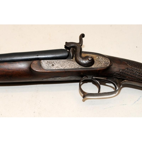 142 - Antique double barrel two trigger shotgun with ornately carved stock. O/all length 122cms. Mechanism... 