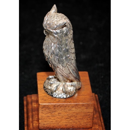 262 - Hallmarked sterling silver Owl mounted on a wooden stepped plinth. Not filled 137g silver weight, o/... 