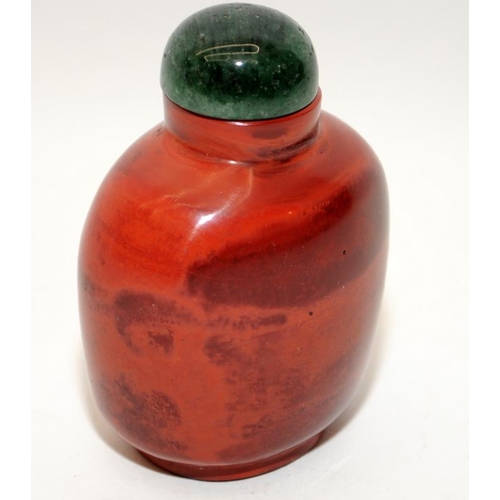 107 - Chinese red Realgar-style snuff bottle with a green hard stone stopper together with another dragon ... 