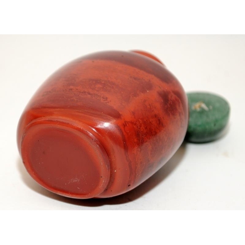 107 - Chinese red Realgar-style snuff bottle with a green hard stone stopper together with another dragon ... 