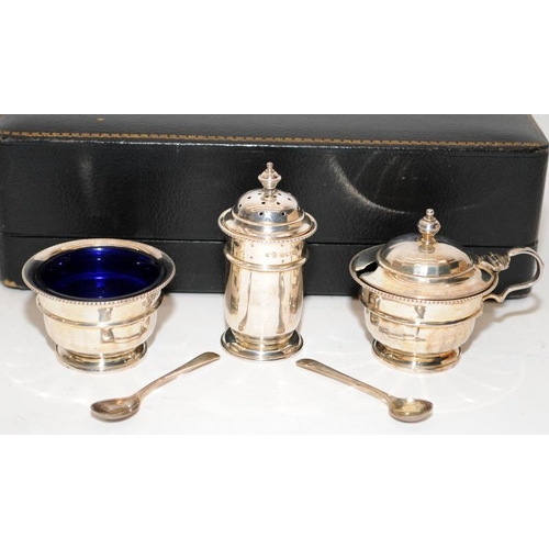 173 - A sterling silver condiment set presented in original case. Pepperette, mustard and salt with blue g... 