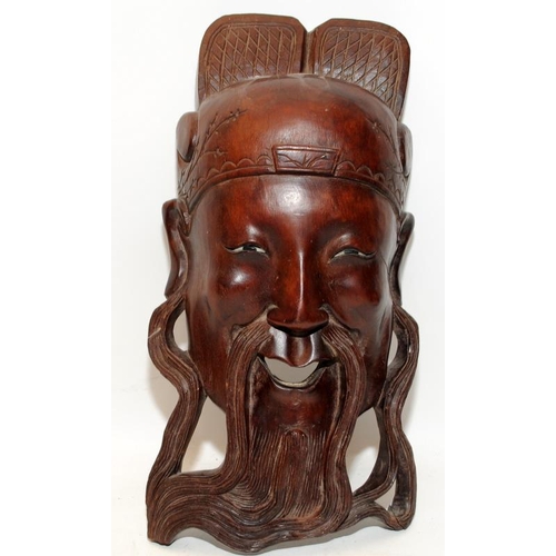 400 - Two vintage carved hardwood Oriental wallhanging face masks. The largest being 30cms