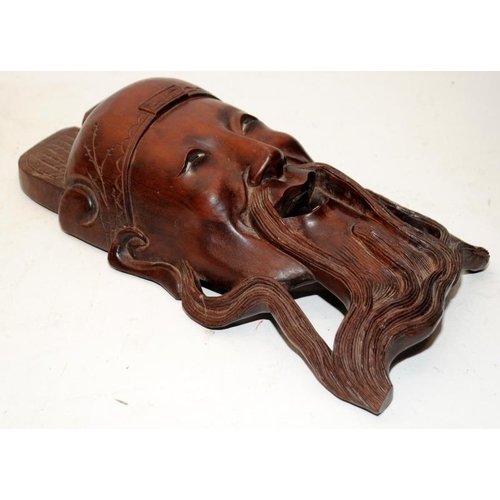 400 - Two vintage carved hardwood Oriental wallhanging face masks. The largest being 30cms