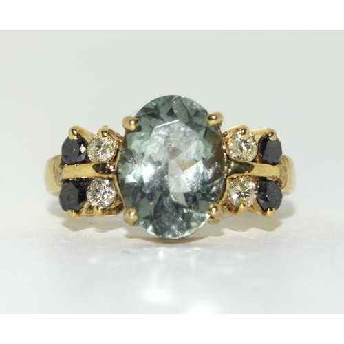 31 - Yellow metal Black and White Diamond with Blue Topaz centre stone. Size Q.