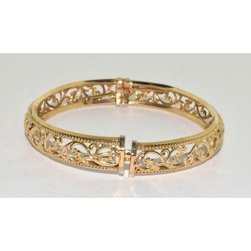 450 - 9ct gold open work bangle with spring closed mechanism, 9.3g