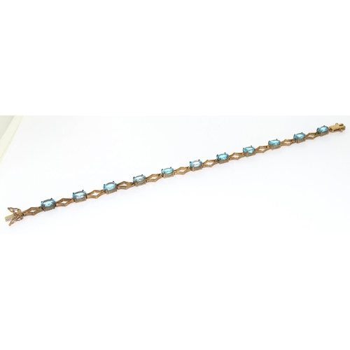 507 - 9ct gold and blue topaz line bracelet 71/2 