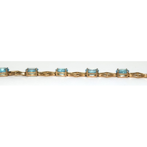 507 - 9ct gold and blue topaz line bracelet 71/2 